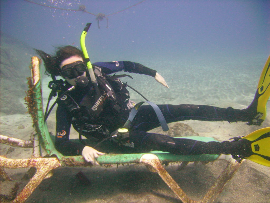 A man in scuba gear reclinign on an underwater sun lounger
