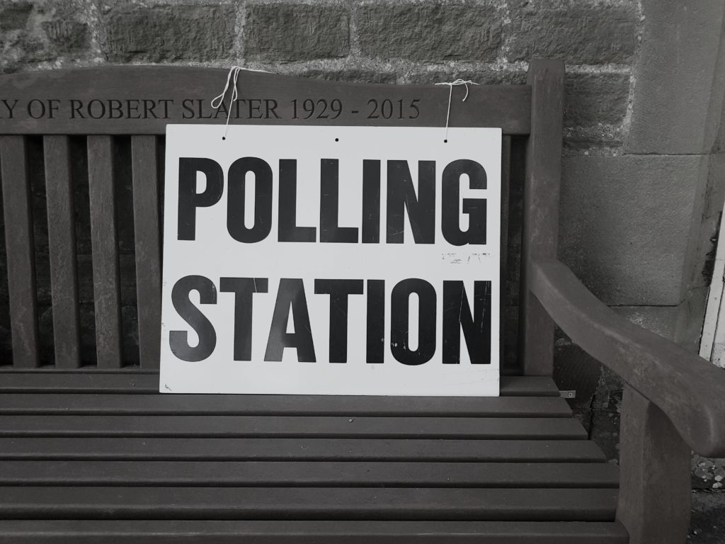 Polling station sign on a wooden bench