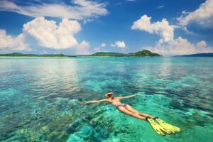 A Woman snorkelling in clear blue waters